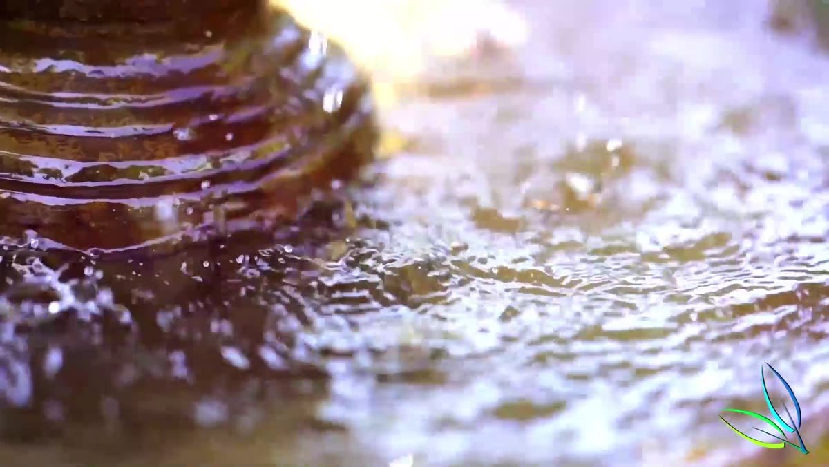 Sunlit water spilling over a glazed ceramic fountain